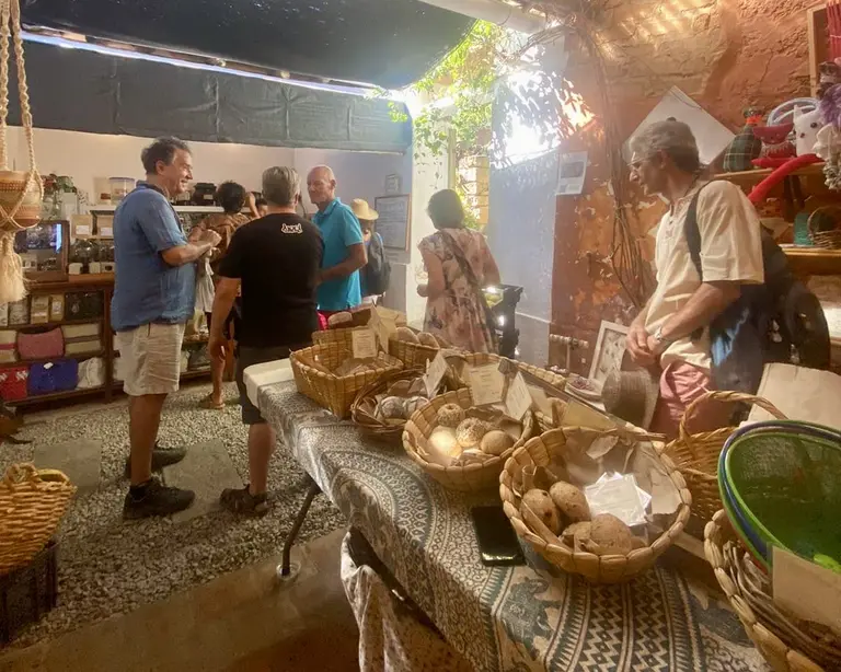 Gente comprando pan artesanal en Casa Común. Mercado local.