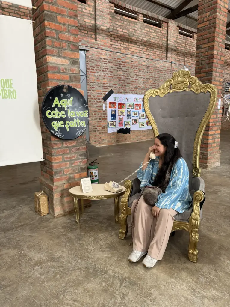 Mujer sentada en un trono dorado hablando por teléfono. "Aquí cabe la voz que falta".